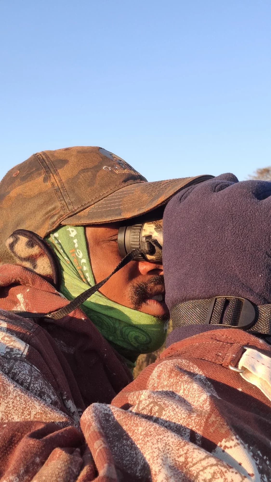 A close-up of a person looking through binoculars