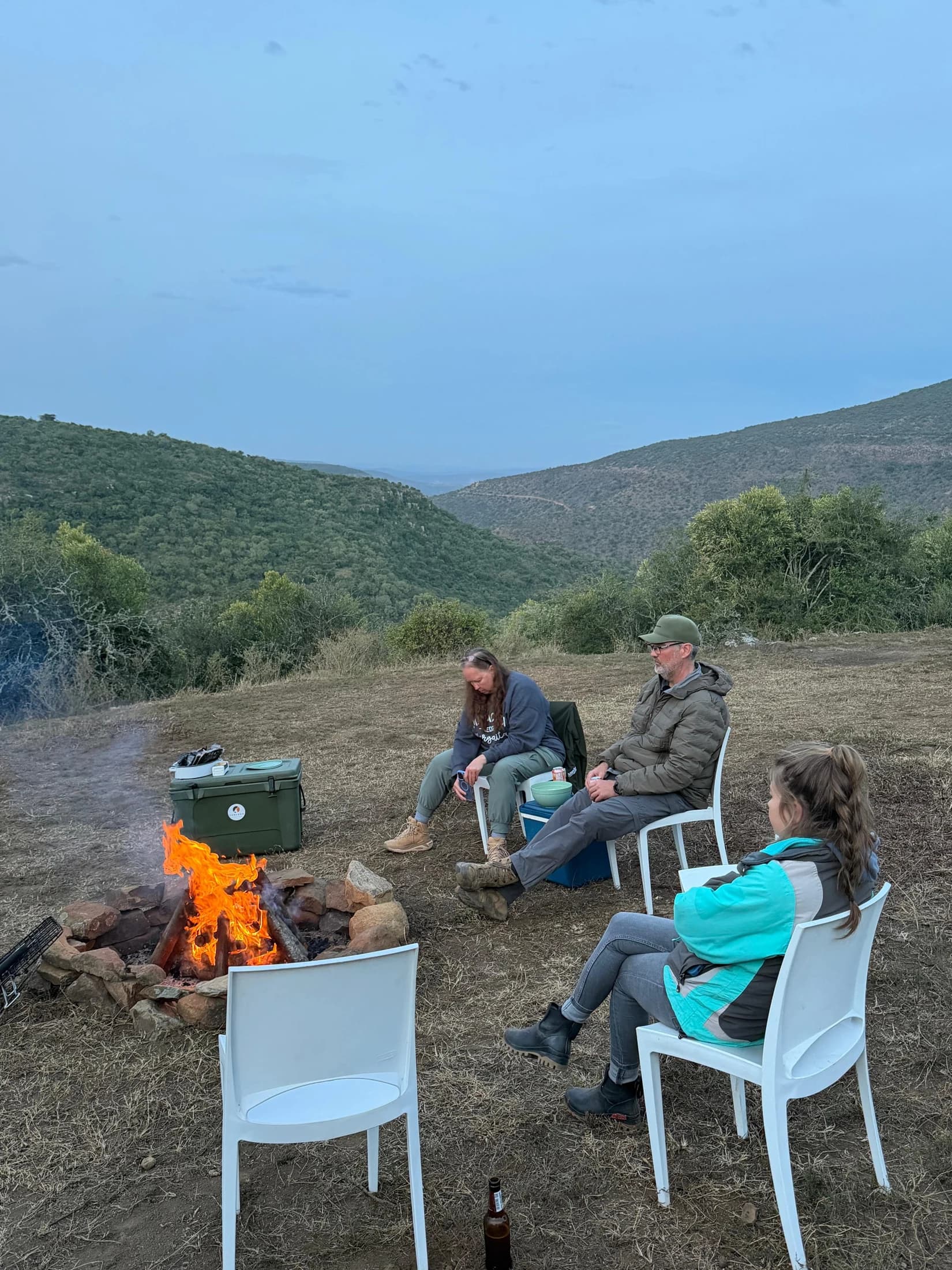 People gathered around a fire overlooking a valley
