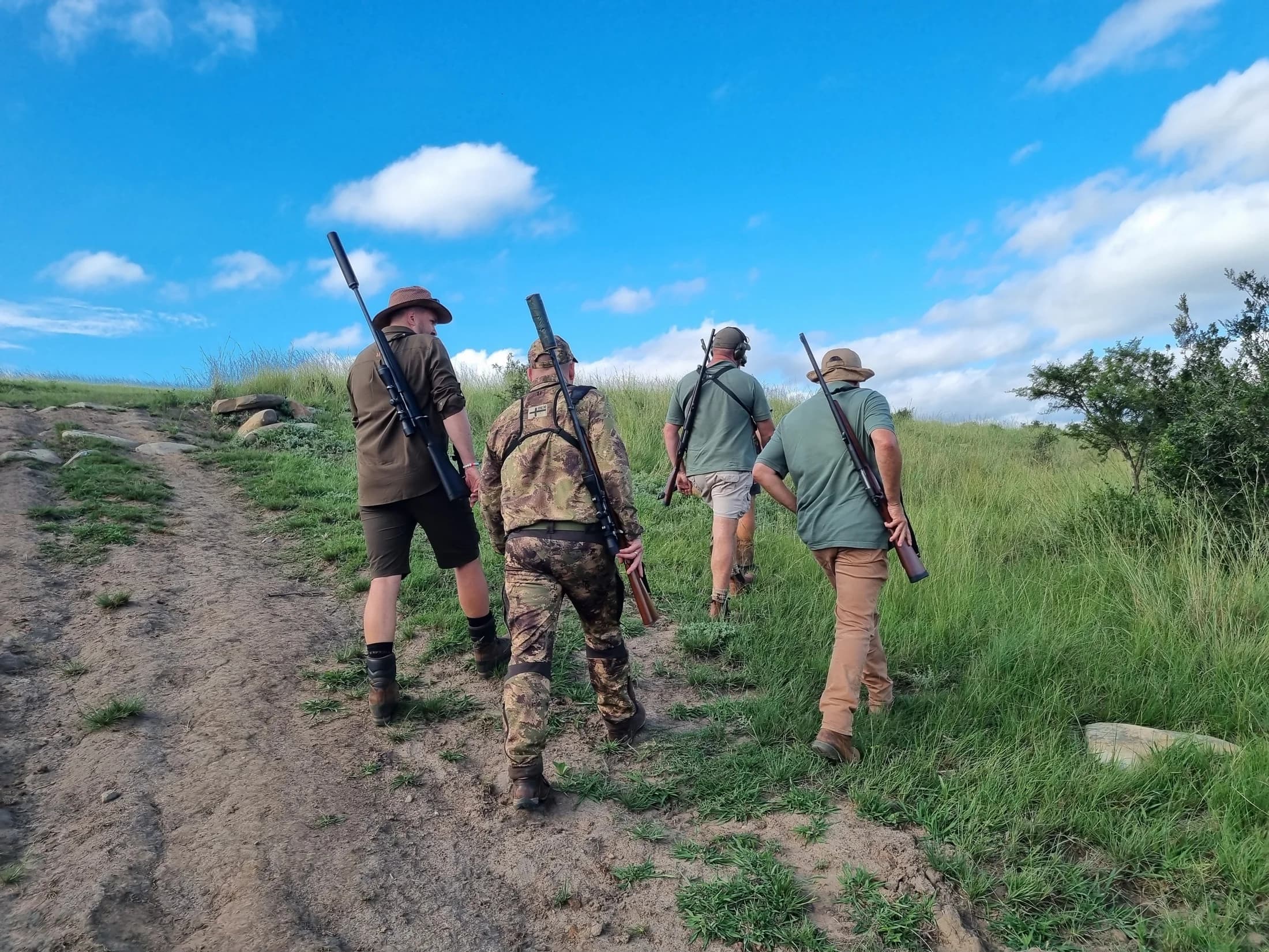 A hunting group walking along a track with their equipment