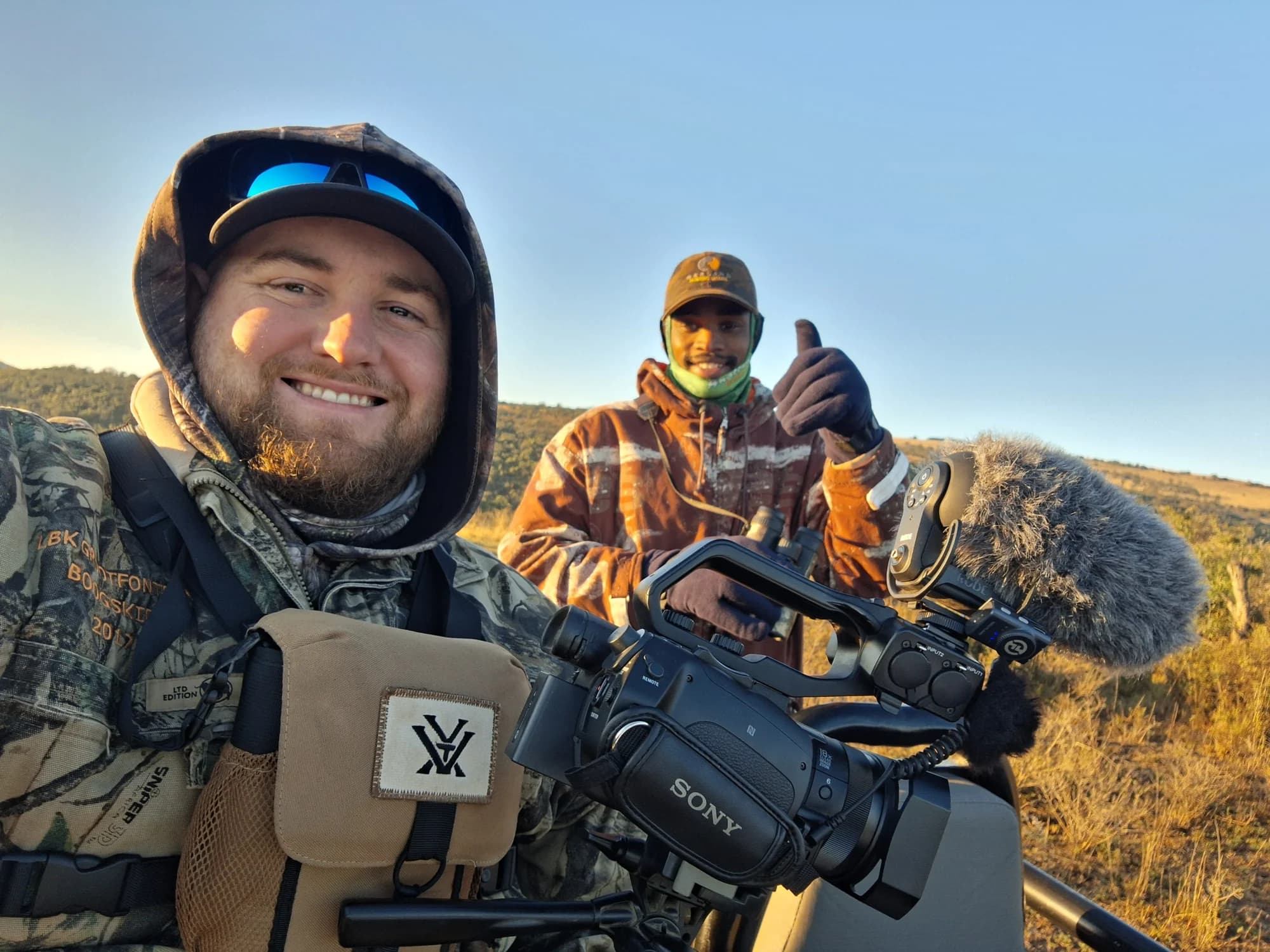 Two people outdoors with a video camera