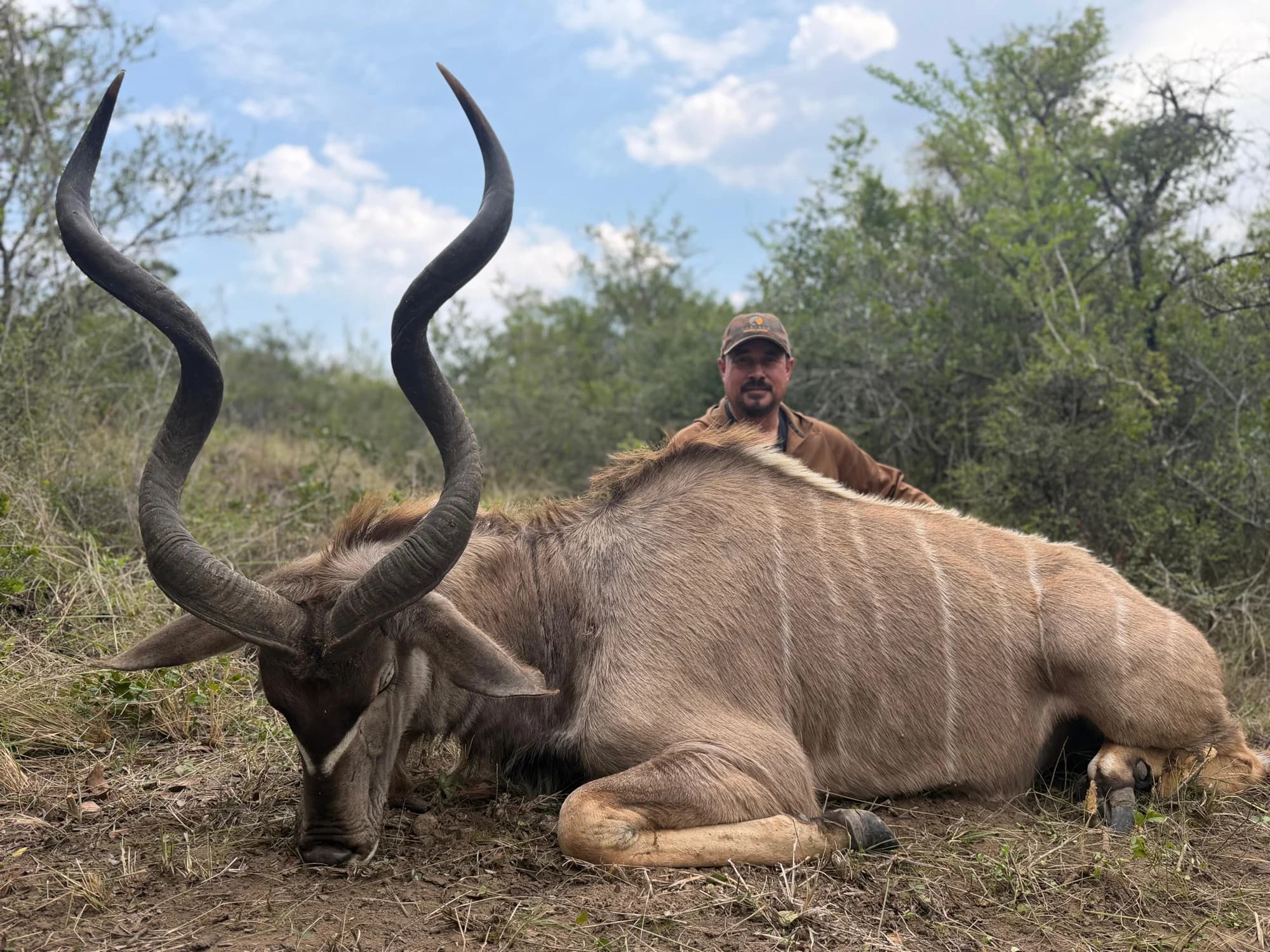 Hunting trophy photograph of an antelope with a hunter behind it