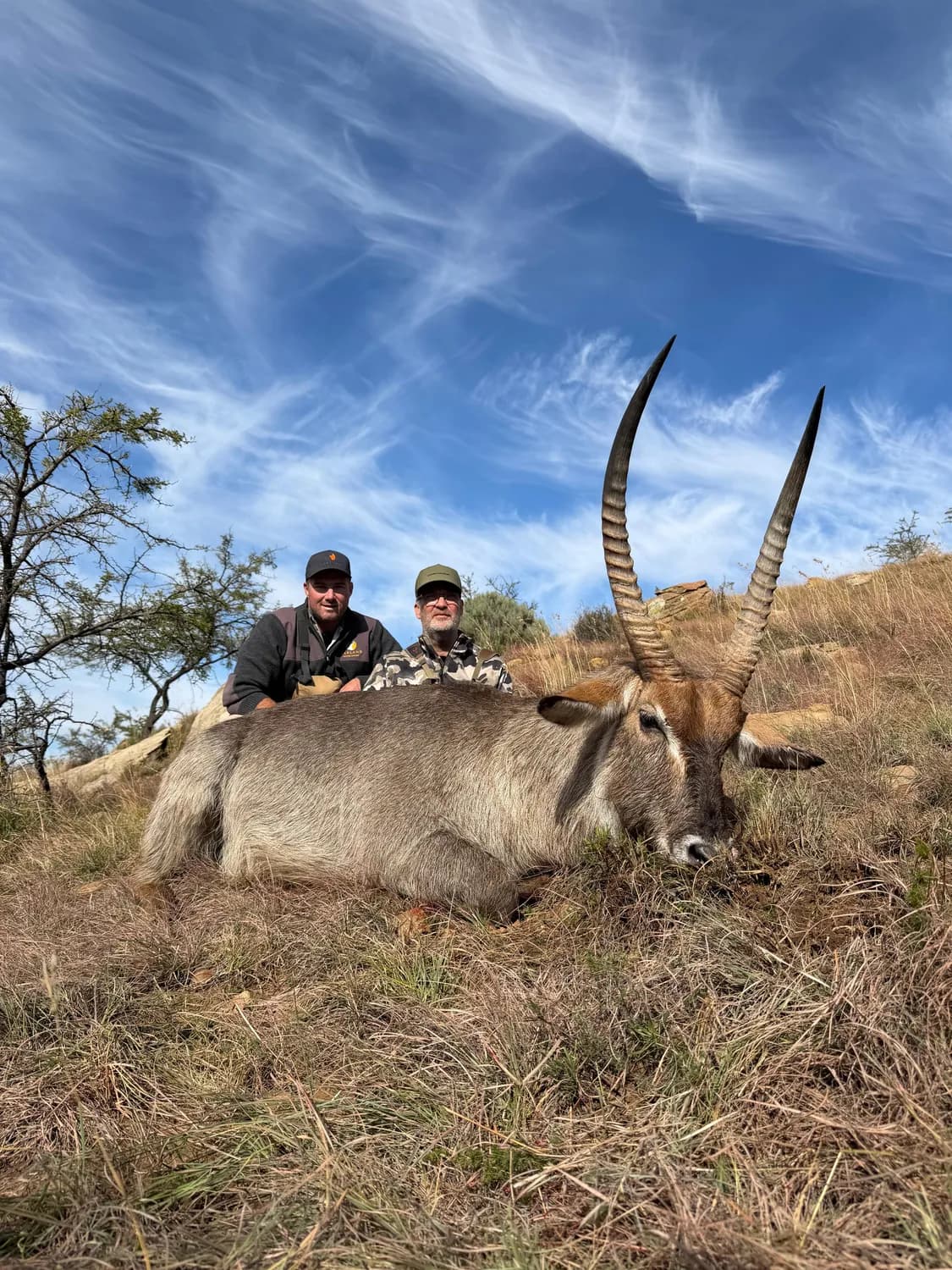 Two hunters behind a harvested waterbuck at Garland
