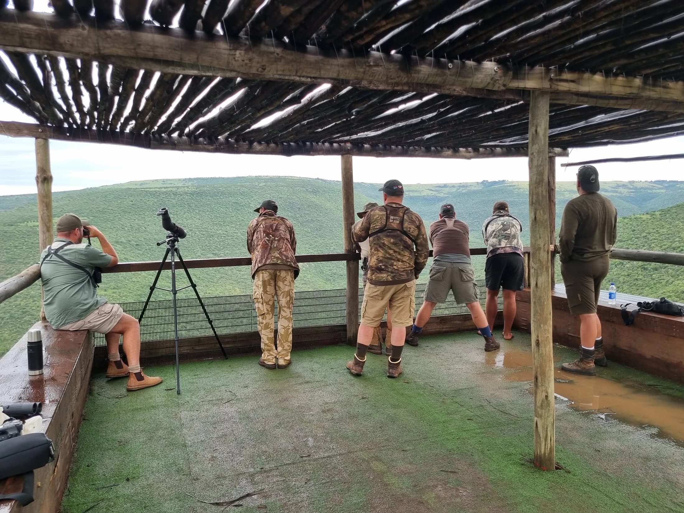 A group observing a valley from a covered lookout