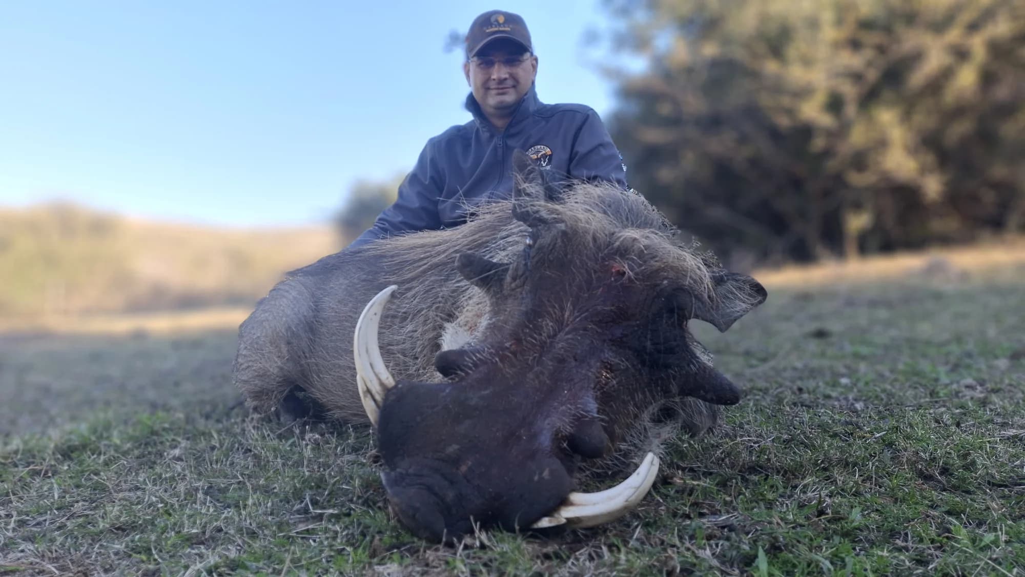 Hunting trophy photograph of a warthog and hunter